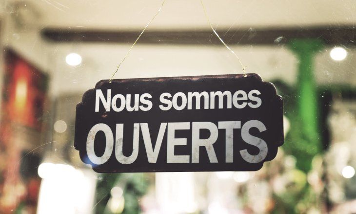 Porte d'un magasin avec un panneau indiquant qu'il est ouvert.