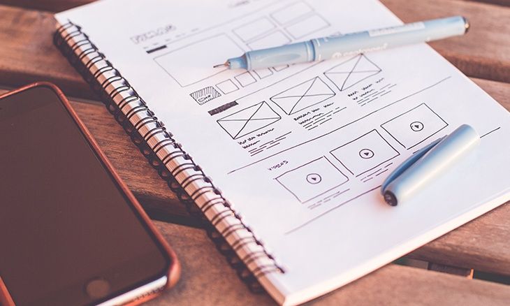 Image d'un cahier où sont dessinés des mock-up d'UX design.