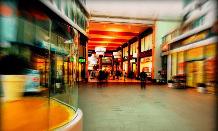 Photo avec effet dynamique d'une galerie marchande avec des commerces de détail.